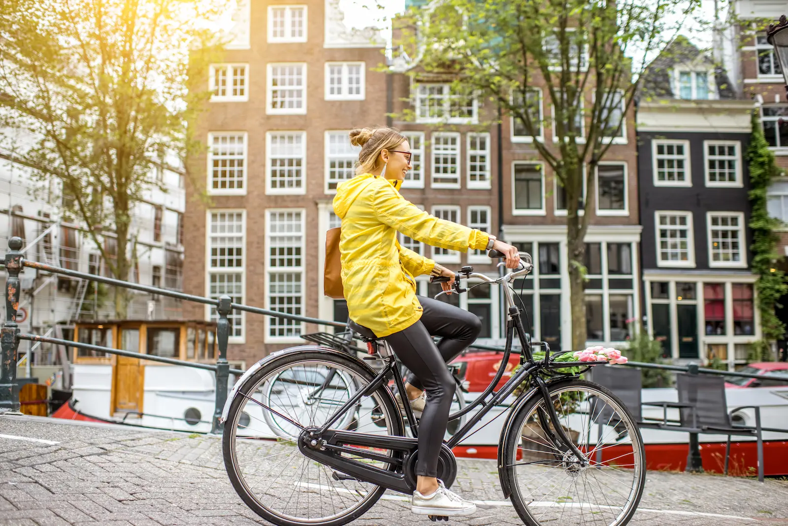 Bike rental Amsterdam - Beautiful canal scene with bicycles parked on bridge, typical Dutch architecture